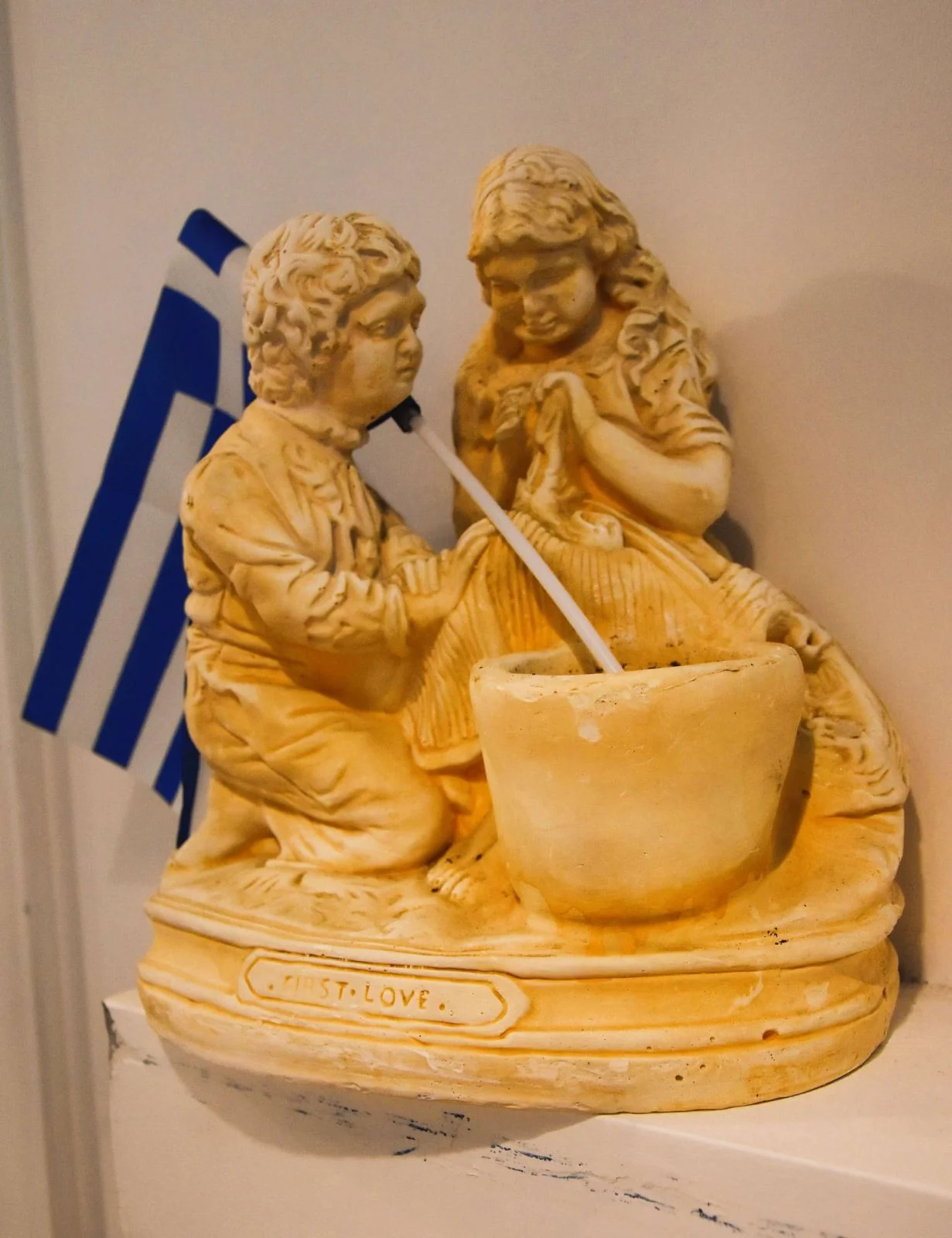 Dekoracyjne figurki i grecka flaga.